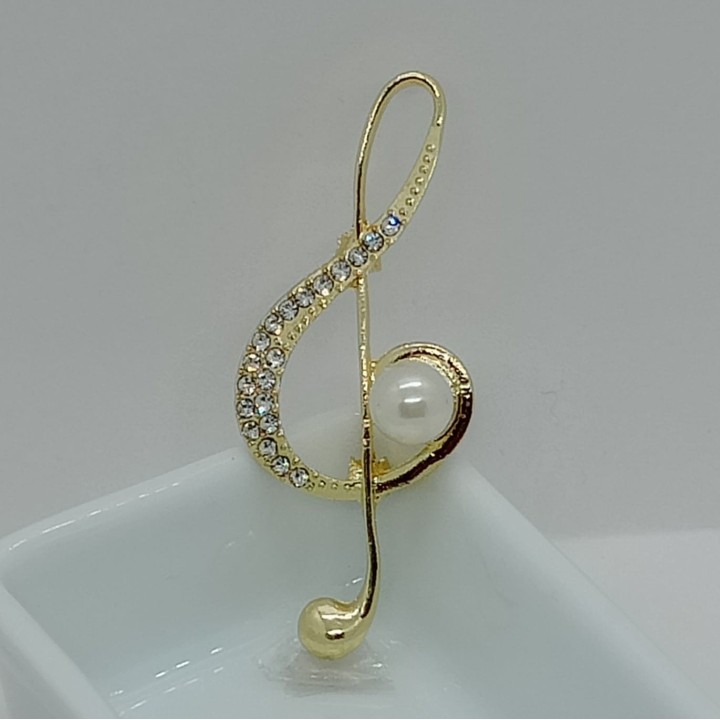 bijou fantaisie emblématique, clé de sol, symbole musical.