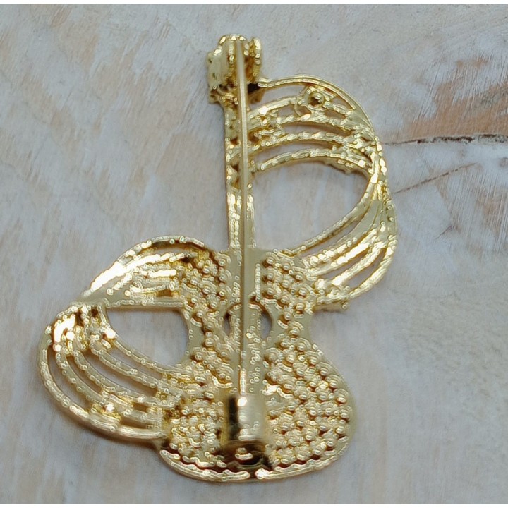 La broche guitare associée à un sac ou un chapeau pour un style original et élégant.