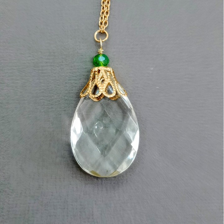 Collier talisman pour femme créé à partir d'un bijou pendule en pampille de lustre transparent facetté et chaîne dorée.