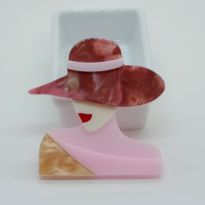 Détail des finitions d'un bijou fantaisie original en acrylique avec châle rose et paillettes dorées
