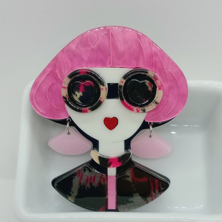 Broche en acrylique femme, cheveux roses carré boule, lunettes écaille orangées, boucles d'oreilles roses