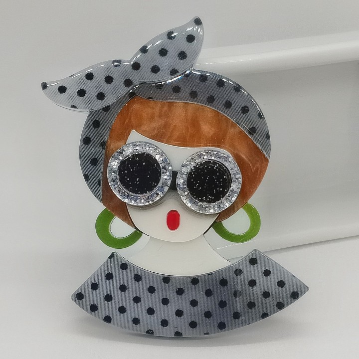 Broche en acrylique femme blonde, serre-tête gris à pois noirs, lunettes argent, boucles d'oreilles vert turquoise