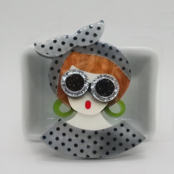 Broche femme blonde, détail du serre-tête gris à pois